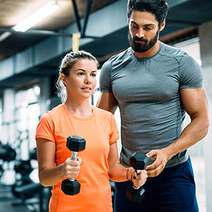 personal trainer working with client in gym